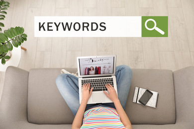 Image of Search bar with text KEYWORDS and woman with laptop on sofa, top view