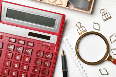 Calculator and stationery on white wooden table, flat lay. Tax accounting