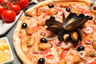 Photo of Tasty fresh pizza with seafood on table, closeup