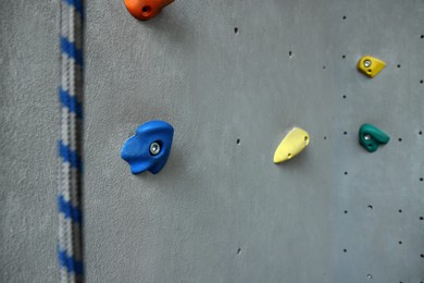 Colorful climbing wall with holds and rope. Extreme sport