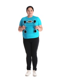 Photo of Overweight woman in sportswear with scales on white background