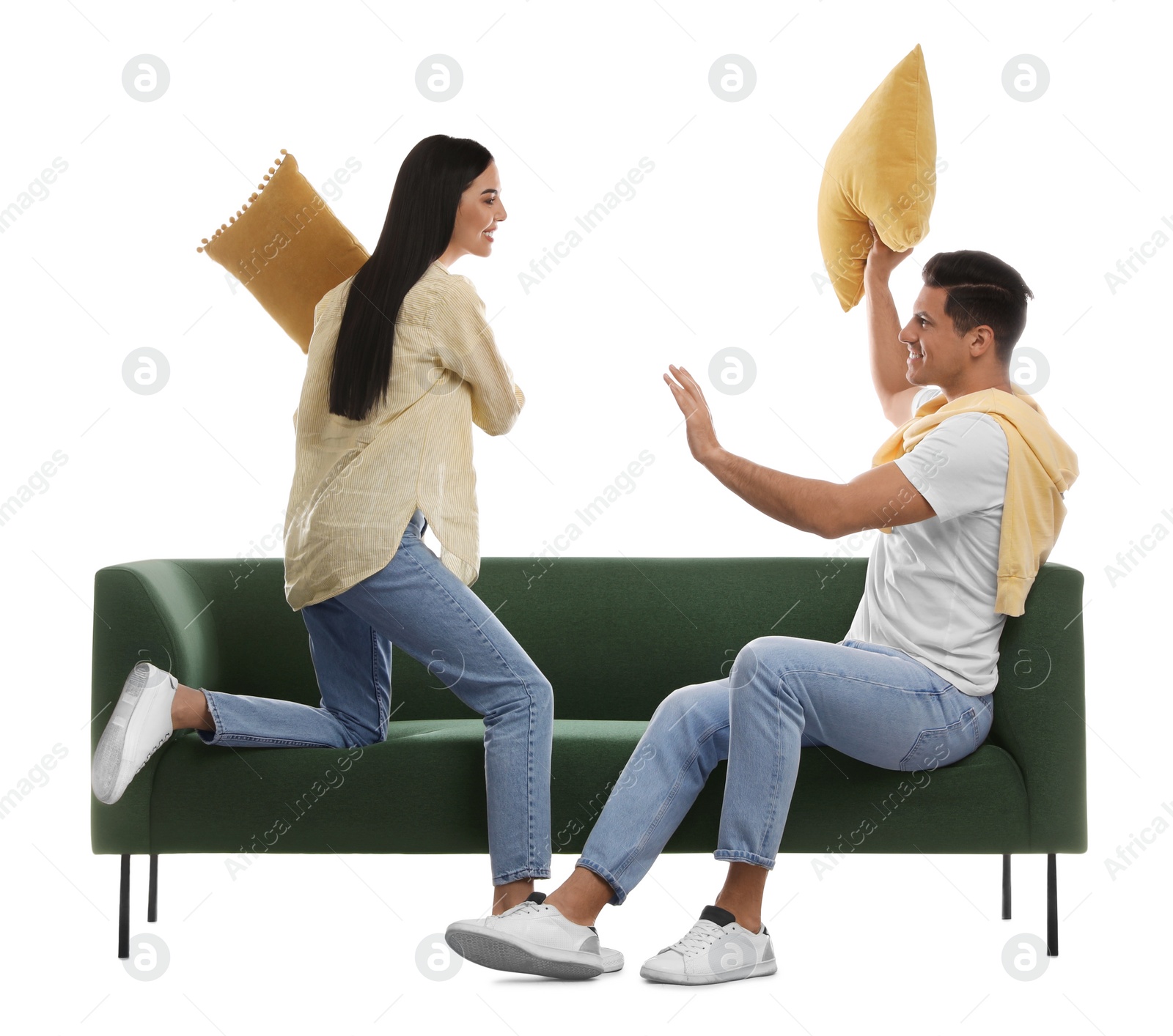 Photo of Happy family having pillow fight on comfortable green sofa against white background