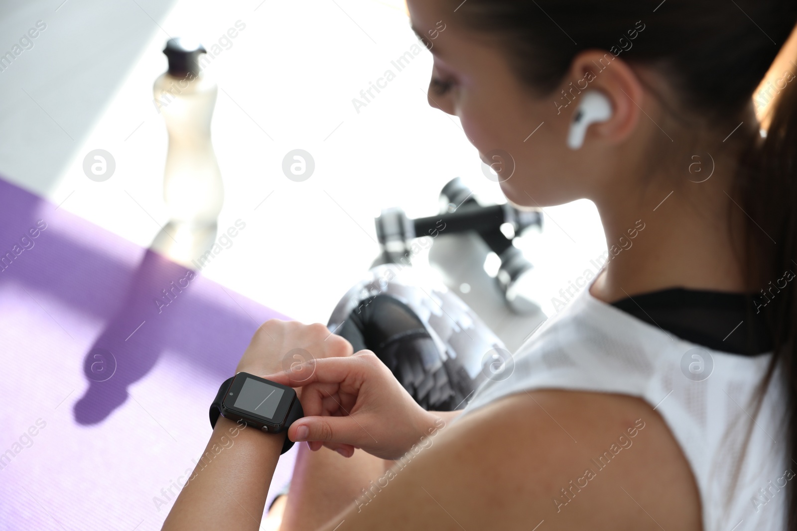 Photo of Woman checking fitness tracker in gym, closeup