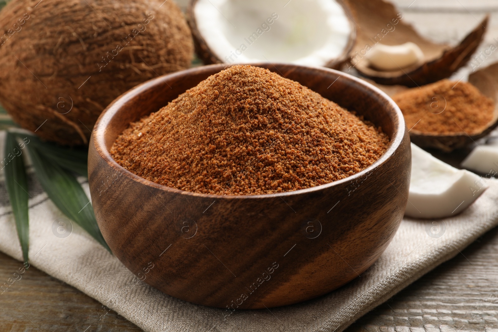 Photo of Natural coconut sugar in bowl on wooden table