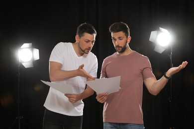 Photo of Professional actors reading their scripts during rehearsal in theatre