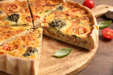 Delicious homemade vegetable quiche on wooden board, closeup