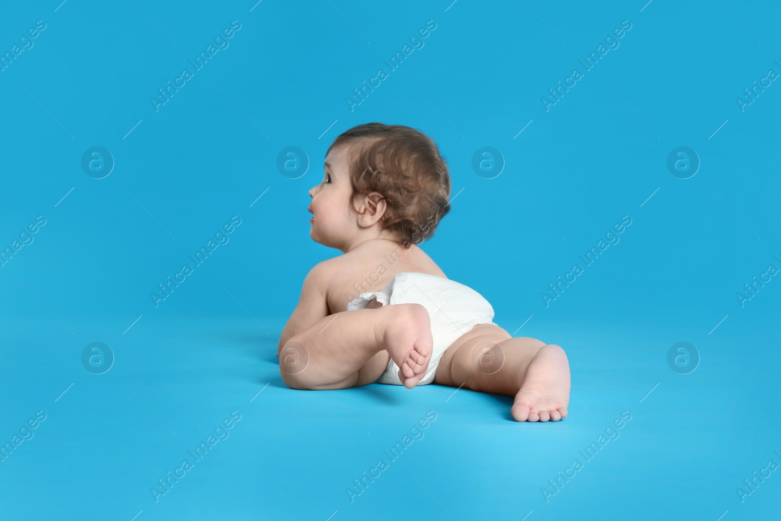 Photo of Cute little baby in diaper on light blue background