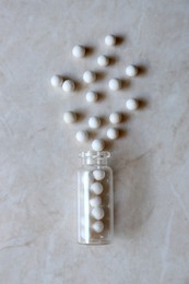 Photo of Bottle with homeopathic remedy on white table, flat lay