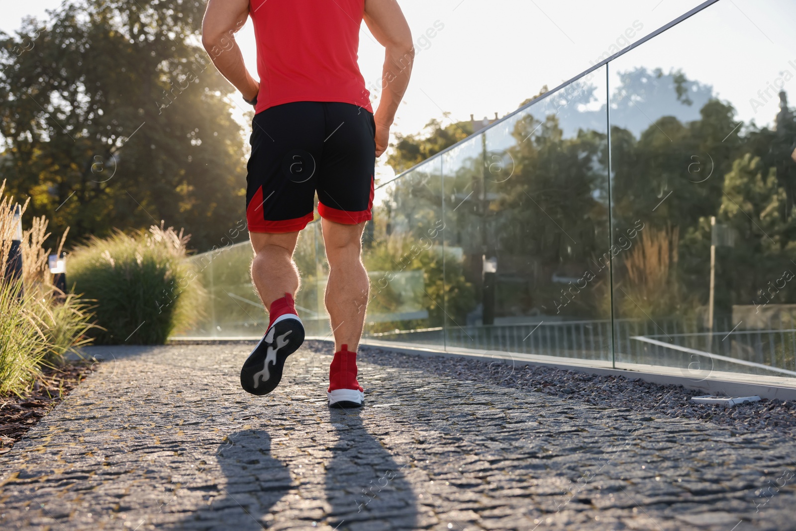 Photo of Man running outdoors on sunny day, closeup. Space for text