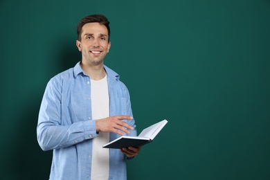 Photo of Portrait of male teacher with book on color background. Space for text
