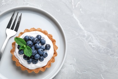 Photo of Tart with blueberries served on marble table, top view with space for text. Delicious pastries