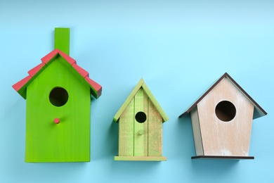 Beautiful bird houses on light blue background, flat lay