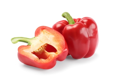 Whole and cut red bell peppers on white background