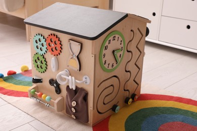 Busy board house on floor indoors. Baby sensory toy