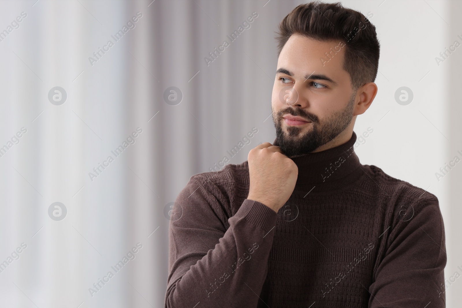 Photo of Handsome man in stylish sweater indoors, space for text