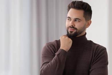 Photo of Handsome man in stylish sweater indoors, space for text