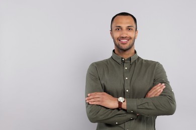 Portrait of handsome young man on gray background, space for text