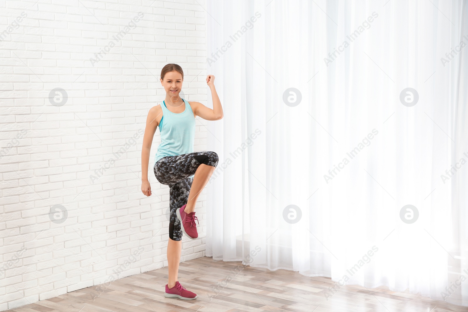 Photo of Young woman doing fitness exercises at home. Space for text