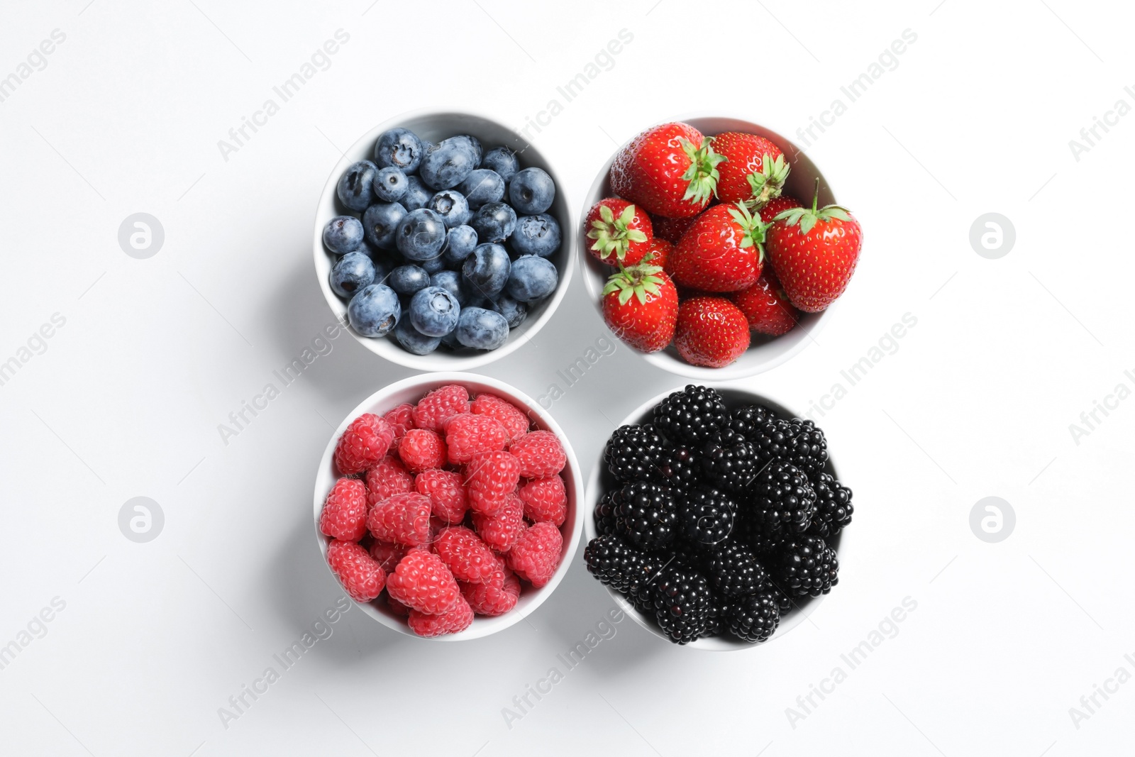 Photo of Bowls with raspberries and different berries on white background