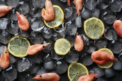 Photo of Flat lay composition with shrimps, lemon slices and ice cubes on dark background