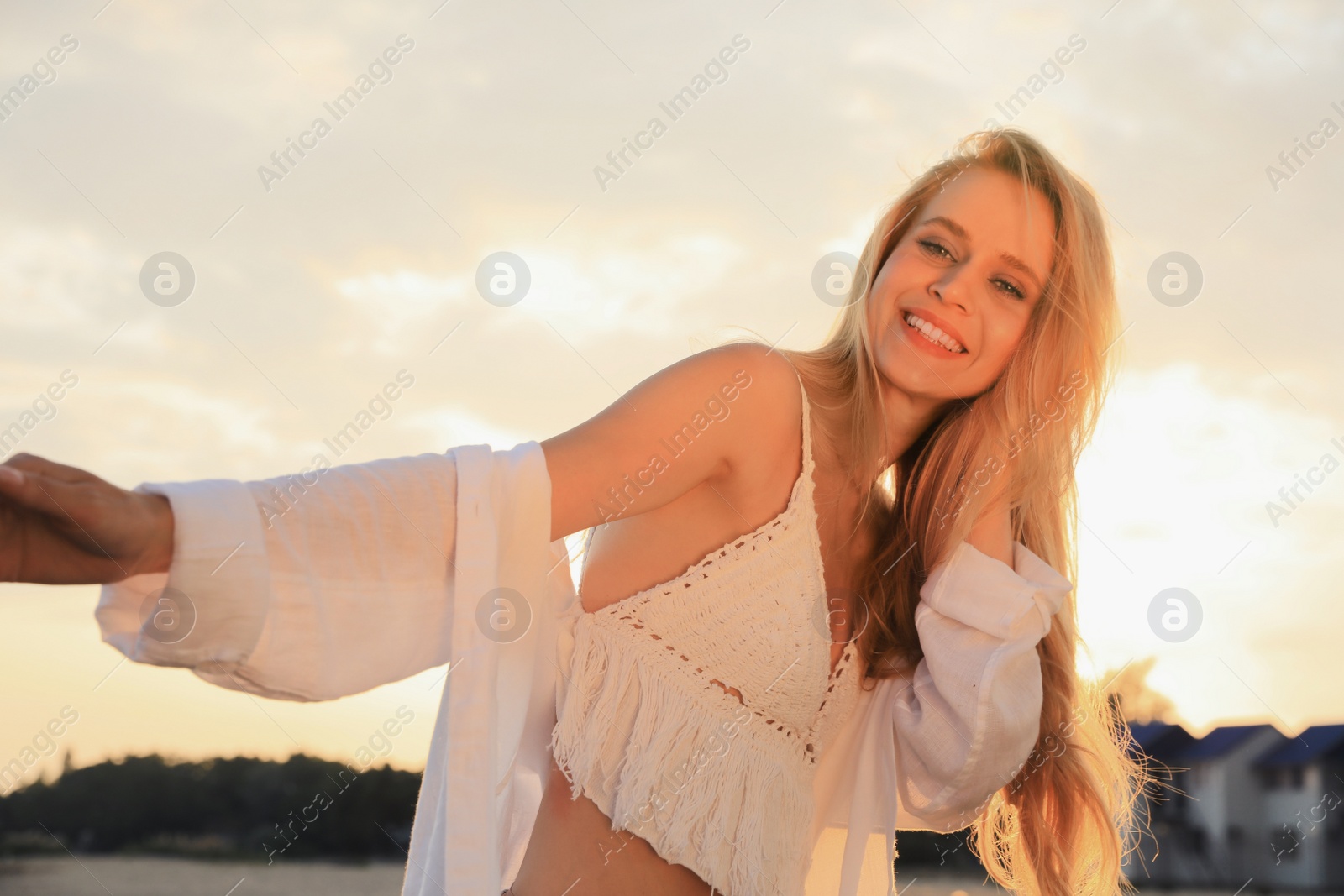 Photo of Happy young woman with beautiful blond hair outdoors at sunset