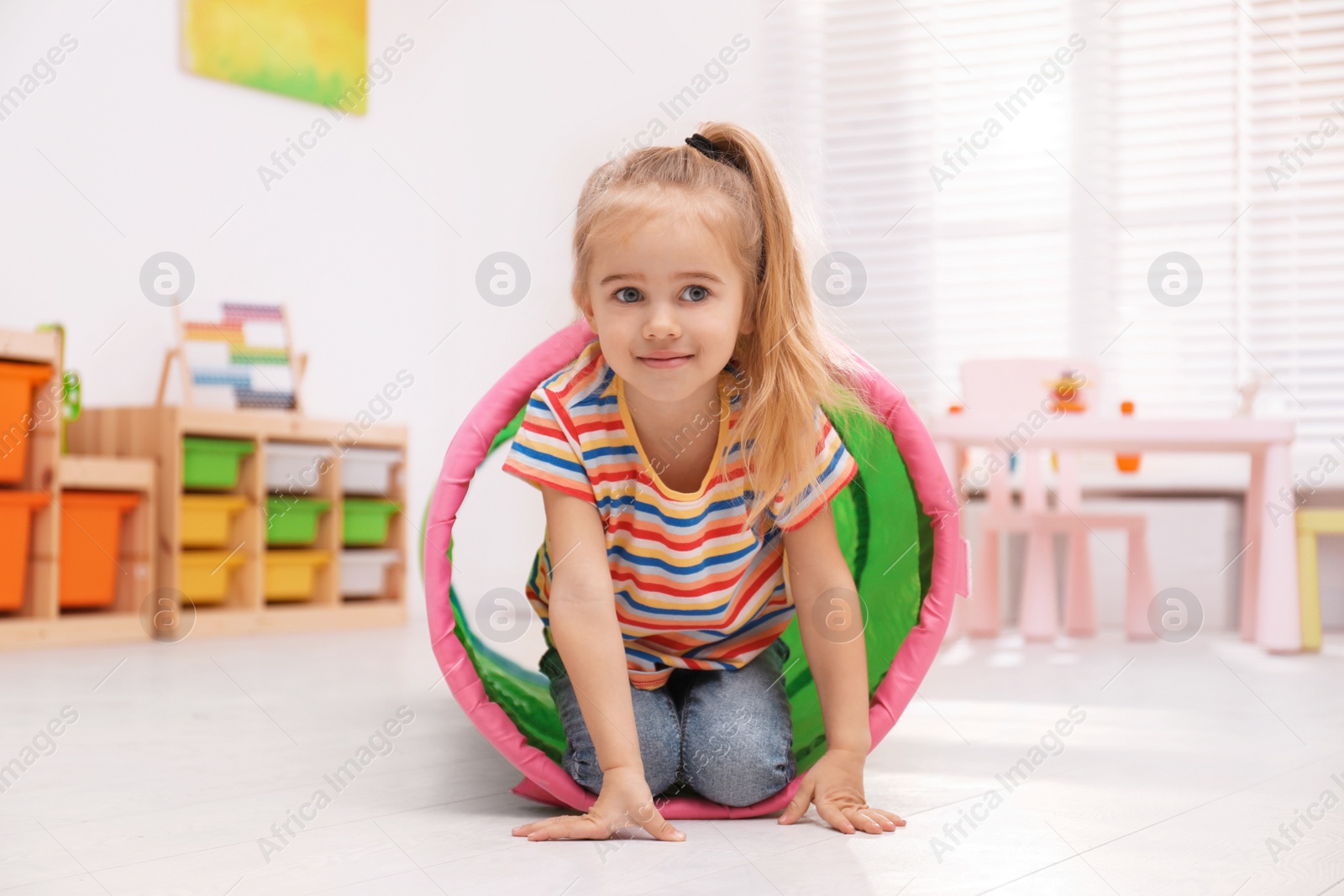 Photo of Cute little child playing on floor at home