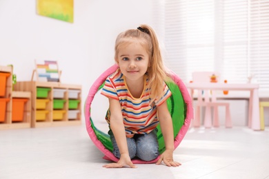 Photo of Cute little child playing on floor at home