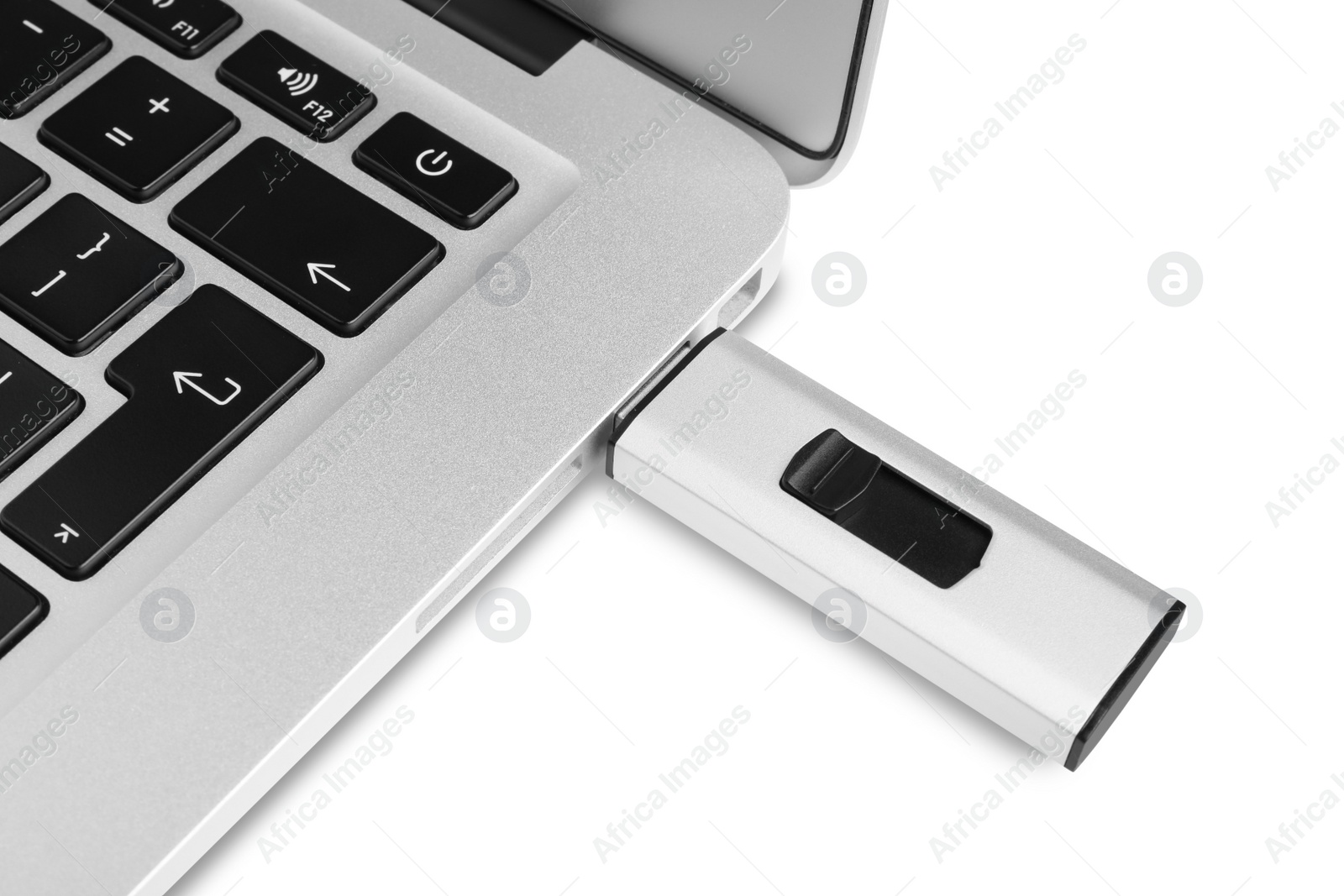 Photo of Modern usb flash drive attached into laptop on white background, closeup