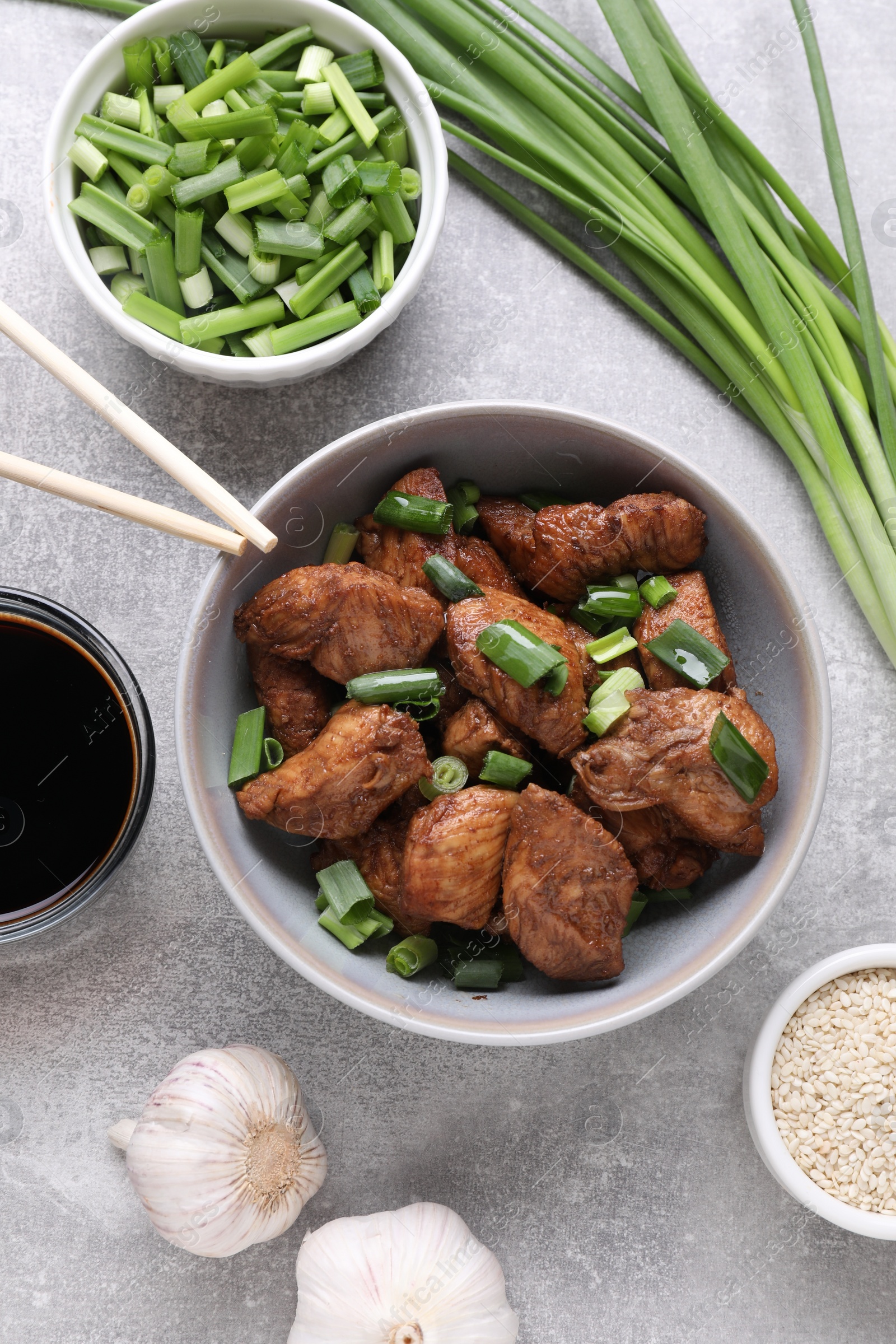 Photo of Tasty soy sauce, roasted meat and ingredients on grey table, flat lay