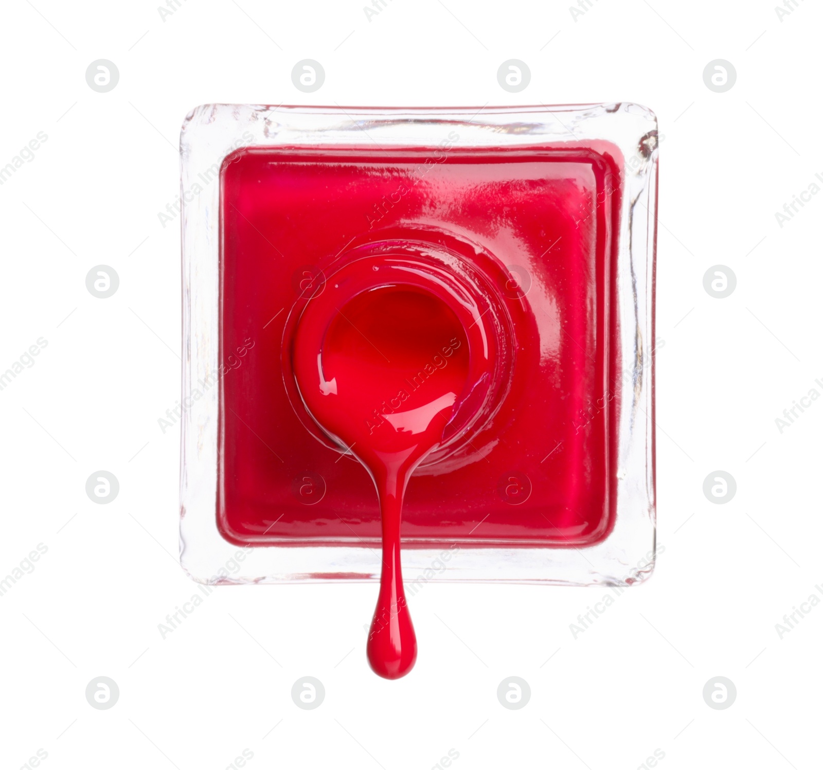 Photo of Red nail polish dripping from bottle isolated on white