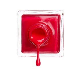 Photo of Red nail polish dripping from bottle isolated on white