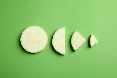 Photo of Fresh ripe cut zucchini on green background, flat lay