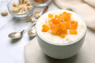 Photo of Delicious rice pudding with dried apricots on table, closeup