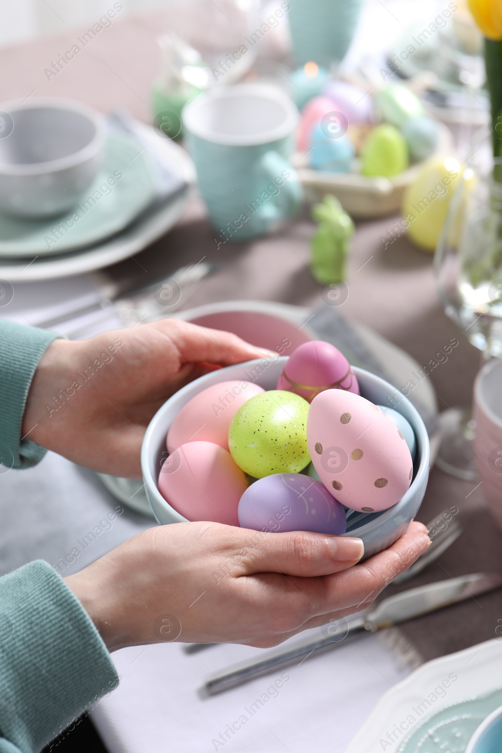 Photo of Woman setting table for festive Easter dinner at home, closeup