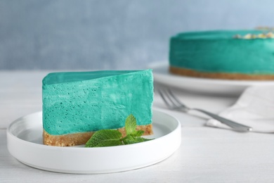 Photo of Delicious homemade spirulina cheesecake served on white wooden table