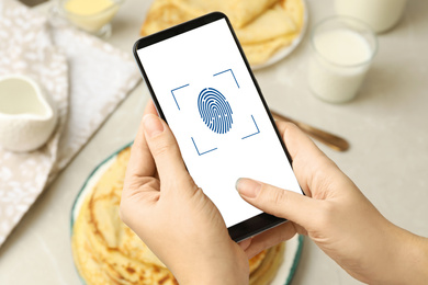 Image of Woman scanning fingerprint on smartphone indoors, closeup. Digital identity