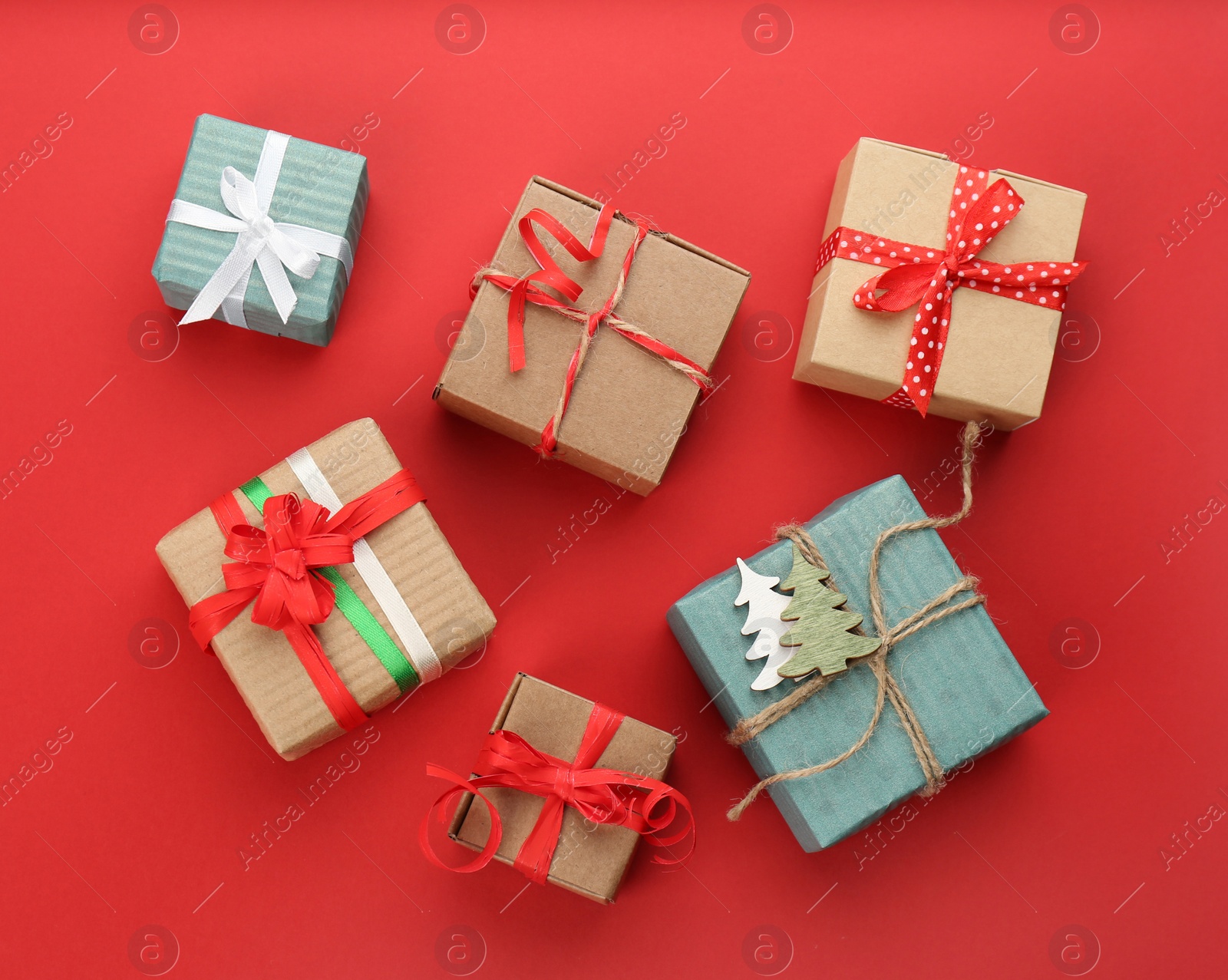 Photo of Christmas gift boxes on red background, flat lay