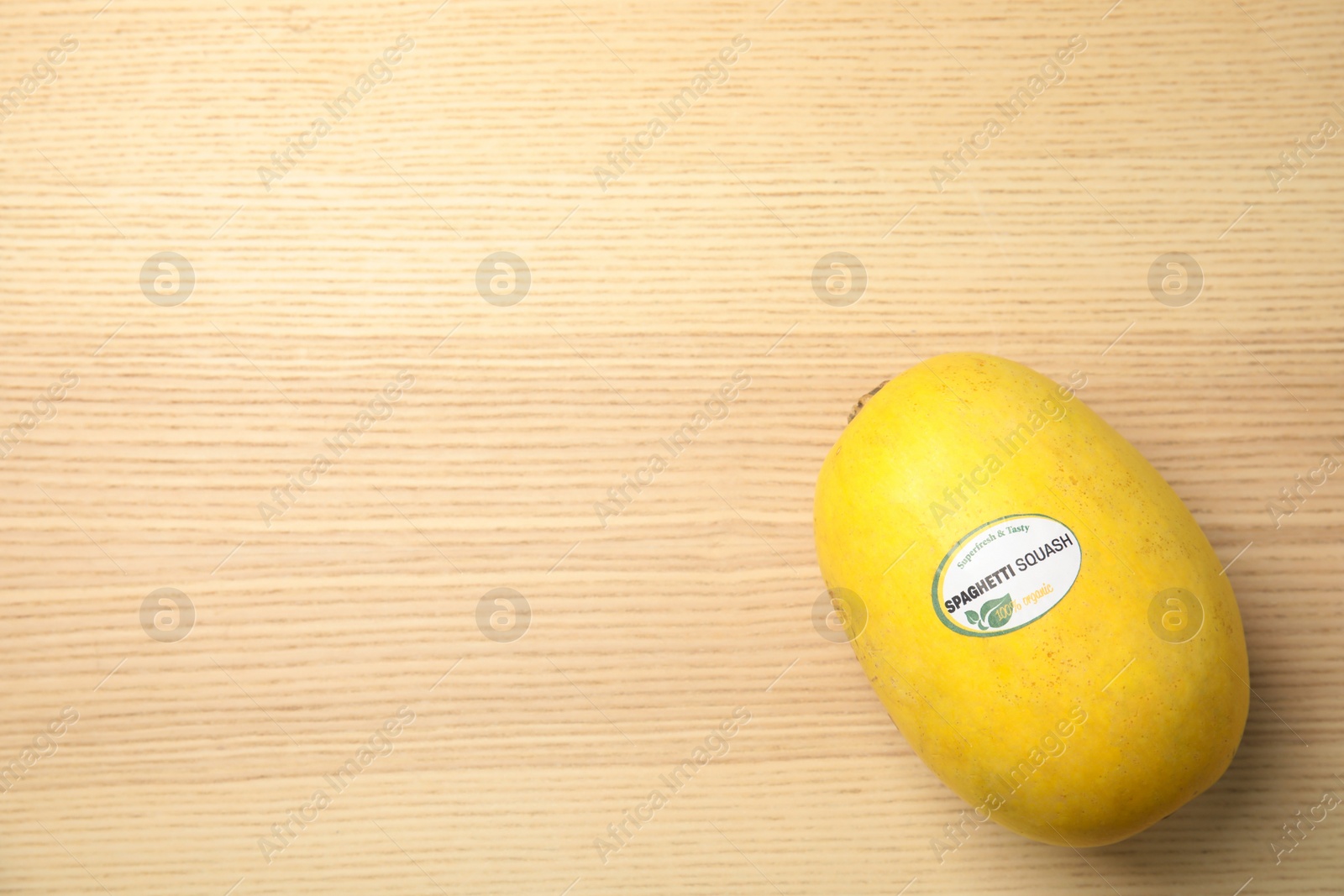 Photo of Whole ripe spaghetti squash on wooden background, top view with space for text