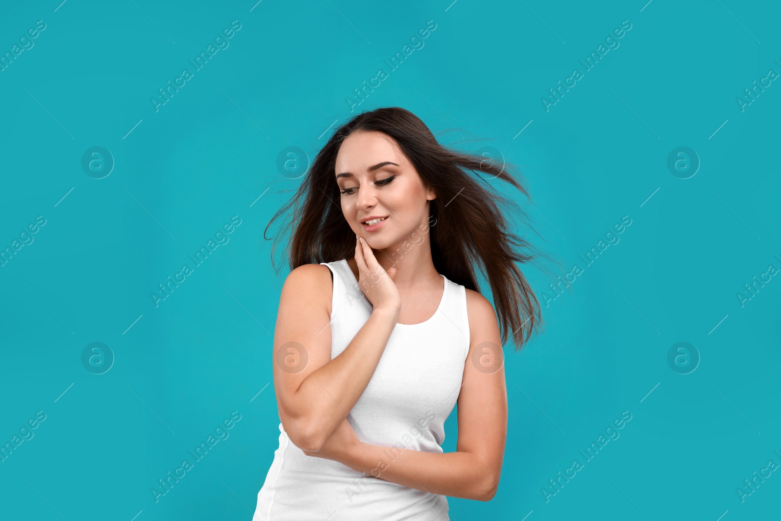 Photo of Beautiful young woman in casual outfit on turquoise background