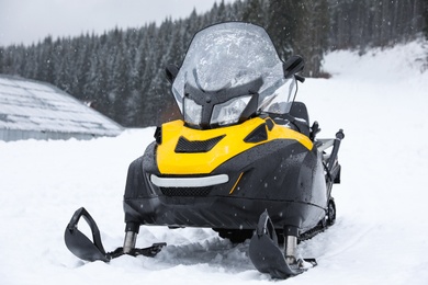 Photo of New stylish snowmobile parked outdoors. Winter recreation
