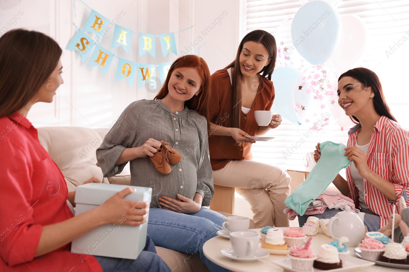 Photo of Happy pregnant woman spending time with friends at baby shower party