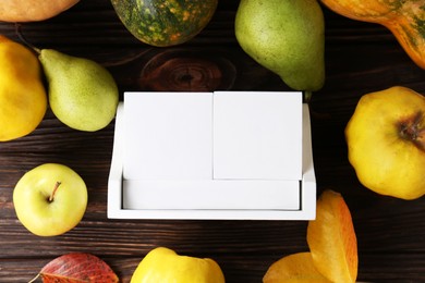 Photo of Thanksgiving day, holiday celebrated every fourth Thursday in November. Block calendar, fruits, vegetables and autumn leaves on wooden table, flat lay