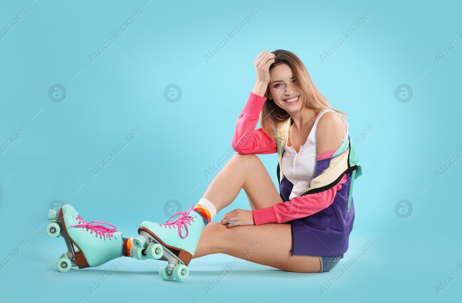 Photo of Young woman with retro roller skates on color background