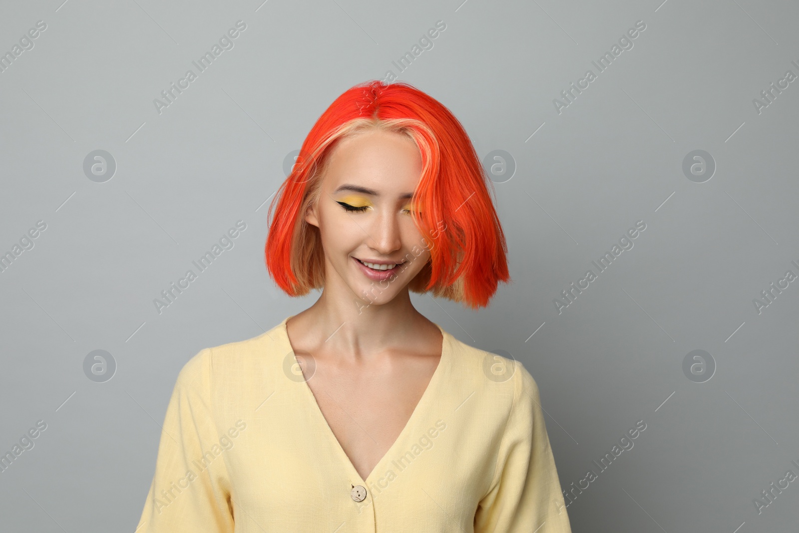 Photo of Beautiful young woman with bright dyed hair on light grey background