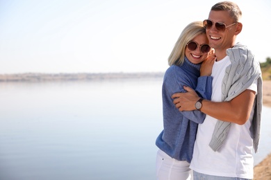 Photo of Happy couple in stylish sweaters on beach