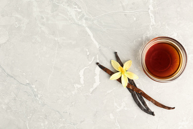 Photo of Flat lay composition with vanilla extract on light grey marble table. Space for text