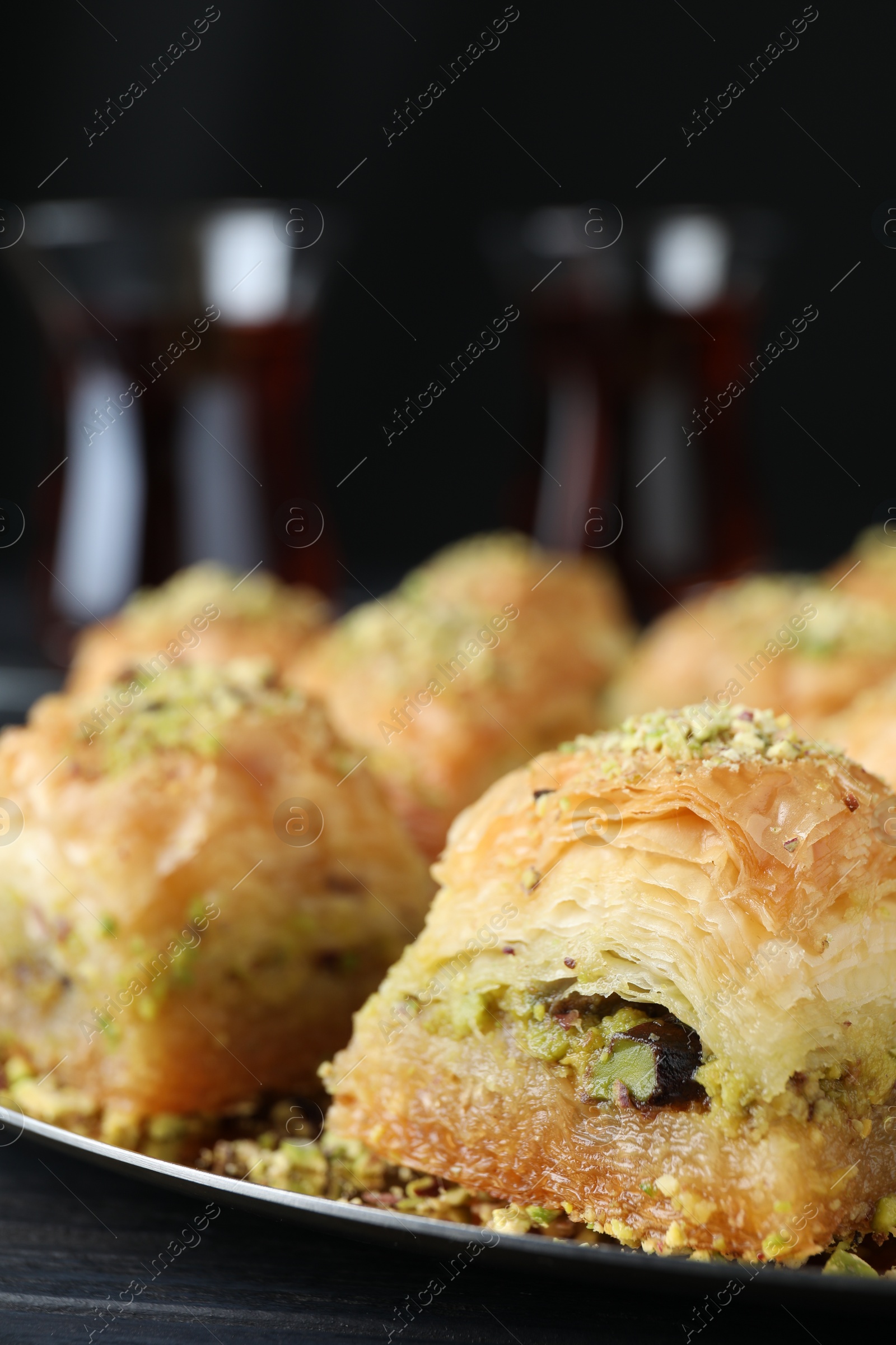 Photo of Delicious fresh baklava with chopped nuts on table, closeup. Eastern sweets