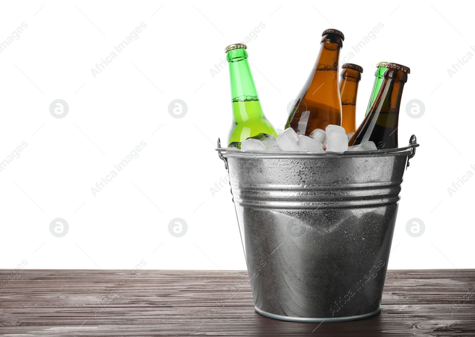 Photo of Metal bucket with bottles of beer and ice cubes on wooden table against white background. Space for text