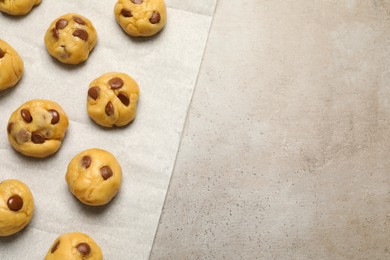 Photo of Unbaked chocolate chip cookies on light grey table, flat lay. Space for text