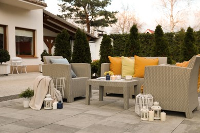 Photo of Beautiful rattan garden furniture, soft pillows and different decor elements in backyard